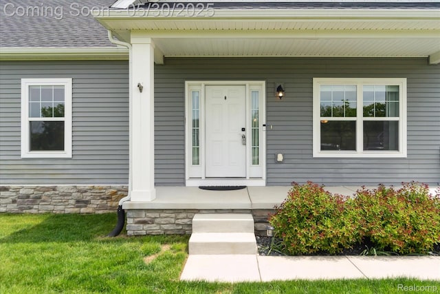 4925 Toratola Ln, Howell, MI 48843 - entrance to property with covered porch, a shingled roof, and a lawn