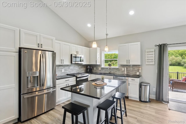 4925 Toratola Ln, Howell, MI 48843 - kitchen with stainless steel appliances, backsplash, a breakfast bar area, white cabinetry, and a sink