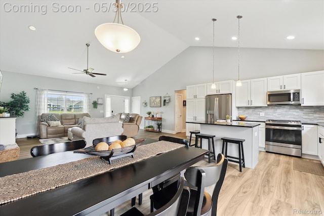 4925 Toratola Ln, Howell, MI 48843 - kitchen with appliances with stainless steel finishes, white cabinetry, light wood-style floors, dark countertops, and a ceiling fan