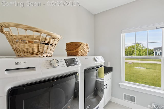4925 Toratola Ln, Howell, MI 48843 - laundry room featuring washer and clothes dryer, cabinet space, light tile patterned floors, and baseboards