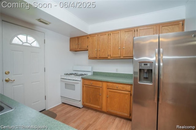 23060 Berdeno Ave, Hazel Park, MI 48030 - kitchen featuring stainless steel fridge, white gas stove, light wood-style flooring, and brown cabinets