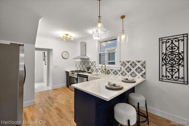 16514 Wildemere St, Detroit, MI 48221 - kitchen featuring wall chimney range hood, stainless steel appliances, tasteful backsplash, a peninsula, and ornamental molding