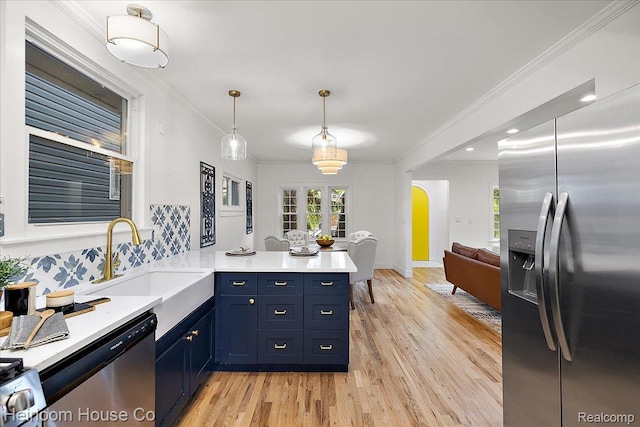16514 Wildemere St, Detroit, MI 48221 - kitchen featuring stainless steel appliances, blue cabinets, a peninsula, a sink, and light wood-style floors