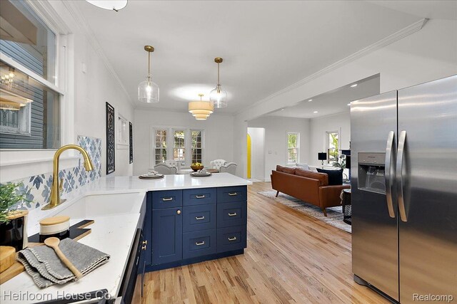 16514 Wildemere St, Detroit, MI 48221 - kitchen with appliances with stainless steel finishes, blue cabinets, a sink, light wood-type flooring, and a peninsula