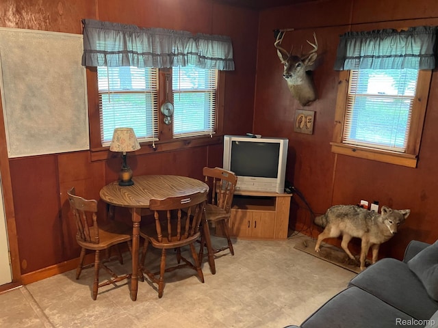 5400 Allen Rd, Alger, MI 48610 - dining space featuring healthy amount of natural light, tile patterned floors, and wood walls