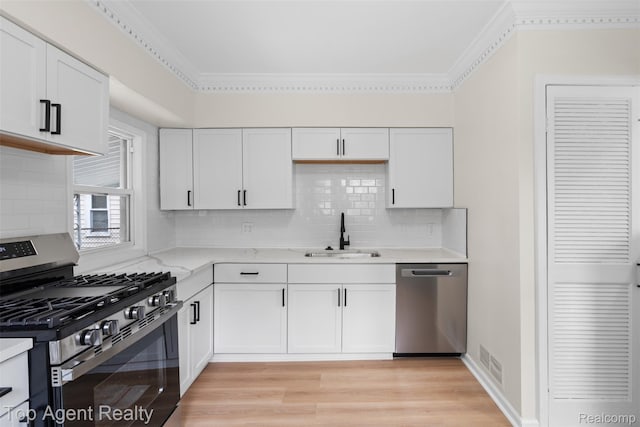 26041 Belanger St, Rochester, MI 48066 - kitchen with stainless steel appliances, a sink, white cabinetry, light wood-style floors, and crown molding
