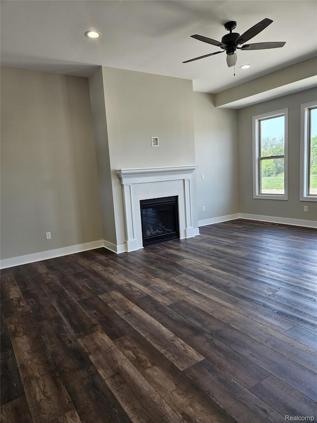 3059 Regatta Dr, St, MI 48079 - unfurnished living room with dark wood-type flooring, ceiling fan, baseboards, a glass covered fireplace, and recessed lighting