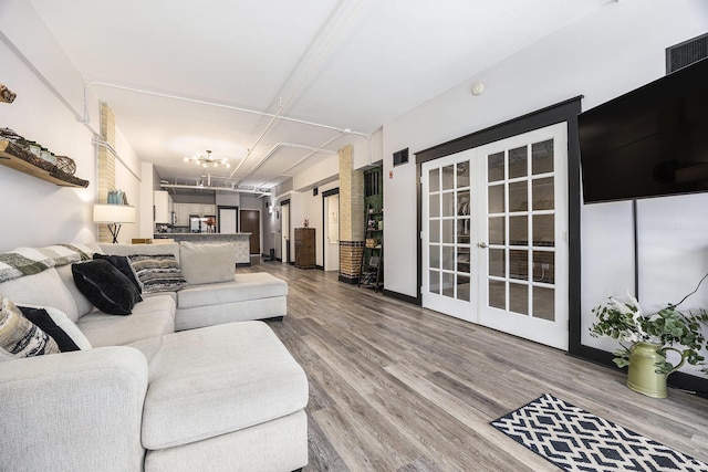 600 Broadway Ave NW Unit 117, Grand Rapids, MI 49504 - living room featuring french doors, wood finished floors, and a chandelier