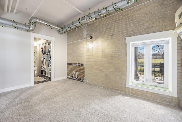 600 Broadway Ave NW Unit 117, Grand Rapids, MI 49504 - unfurnished living room with brick wall, carpet, and baseboards