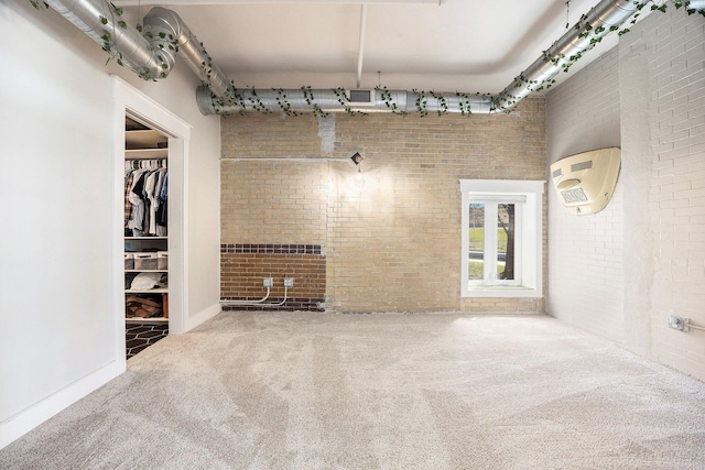600 Broadway Ave NW Unit 117, Grand Rapids, MI 49504 - unfurnished living room featuring brick wall and carpet flooring