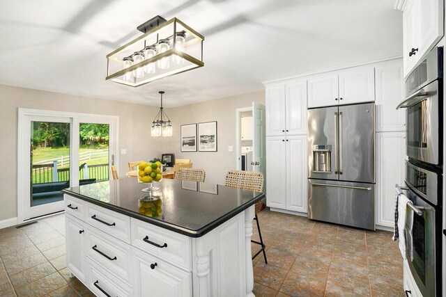 2032 Dean Dr, Washington, MI 48094 - kitchen with stainless steel appliances, dark countertops, a chandelier, white cabinets, and a kitchen island