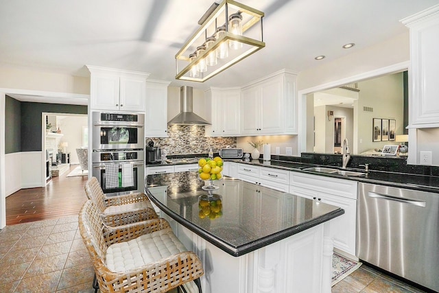 2032 Dean Dr, Washington, MI 48094 - kitchen with stainless steel appliances, wall chimney exhaust hood, white cabinetry, stone tile flooring, and recessed lighting