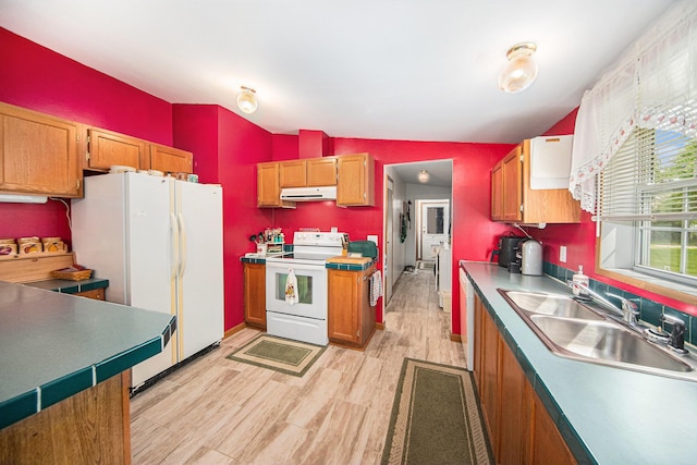 149 Hall St, Michigan Center, MI 49254 - kitchen with white appliances, under cabinet range hood, a sink, light wood-style floors, and brown cabinets