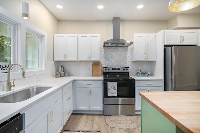 320 Calhoun St, Union City, MI 49094 - kitchen featuring wall chimney range hood, stainless steel appliances, a sink, wood counters, and light wood-type flooring