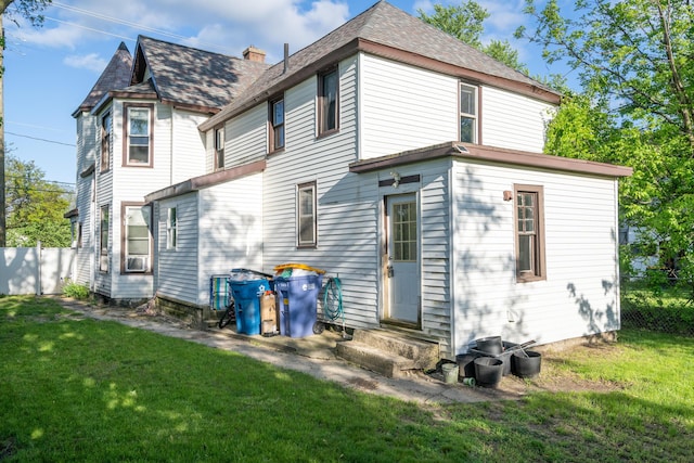 1007 Ionia Ave SW, Grand Rapids, MI 49507 - rear view of house with entry steps, a lawn, cooling unit, and roof with shingles