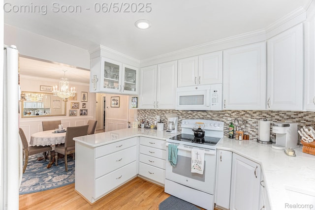 15025 Kipke, Redford, MI 48239 - kitchen featuring white appliances, crown molding, a peninsula, white cabinets, and a chandelier