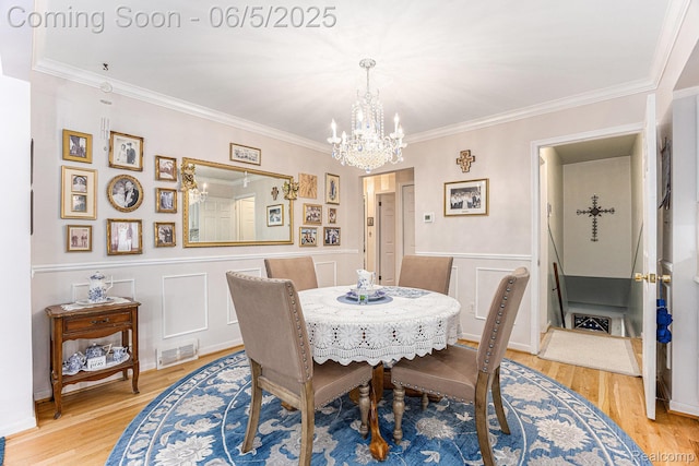 15025 Kipke, Redford, MI 48239 - dining room with a chandelier, ornamental molding, light wood-type flooring, a decorative wall, and wainscoting