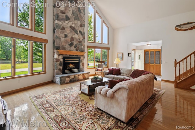 4333 Running Deer Trl, Pigeon, MI 48755 - living room featuring high vaulted ceiling, plenty of natural light, stairway, a stone fireplace, and wood finished floors