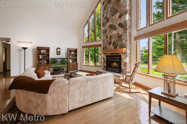 4333 Running Deer Trl, Pigeon, MI 48755 - living room featuring high vaulted ceiling, a stone fireplace, and wood finished floors
