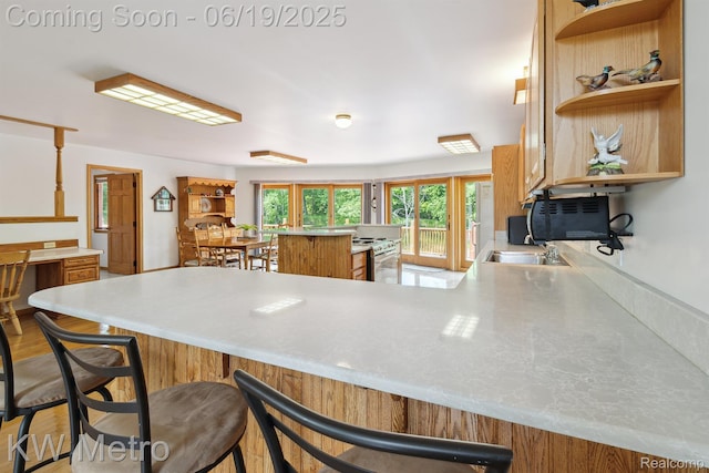 4333 Running Deer Trl, Pigeon, MI 48755 - kitchen featuring open shelves, stainless steel countertops, a kitchen bar, a peninsula, and brown cabinets