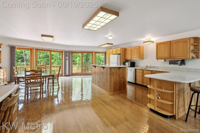 4333 Running Deer Trl, Pigeon, MI 48755 - kitchen featuring open shelves, dishwasher, a kitchen bar, freestanding refrigerator, and light countertops