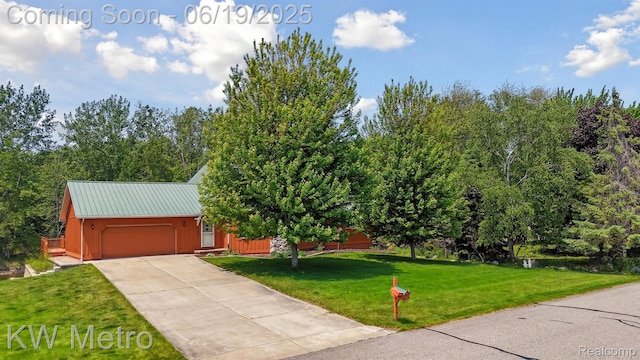 4333 Running Deer Trl, Pigeon, MI 48755 - view of front of house with an attached garage, a front lawn, concrete driveway, and a metal roof