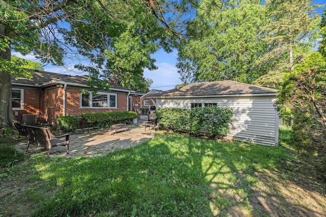 21406 Broadstone St, Harper Woods, MI 48225 - back of house with a yard, central AC unit, brick siding, and a patio