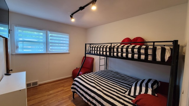 21406 Broadstone St, Harper Woods, MI 48225 - bedroom featuring wood finished floors, rail lighting, and baseboards