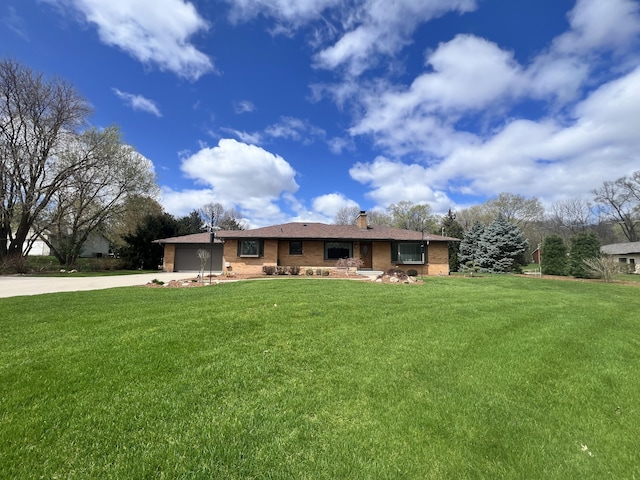 3817 Butterworth St SW, Grand Rapids, MI 49534 - view of front of house with concrete driveway, a garage, a chimney, and a front lawn