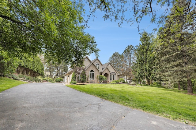 1437 Rillview Ct, Metamora, MI 48455 - view of front of home with a front yard, concrete driveway, stone siding, and an attached garage