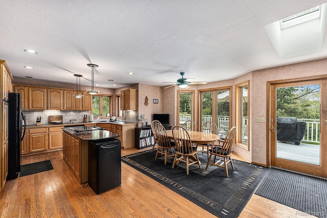 1437 Rillview Ct, Metamora, MI 48455 - kitchen featuring a sink, light wood-style floors, plenty of natural light, a kitchen island, and a textured ceiling