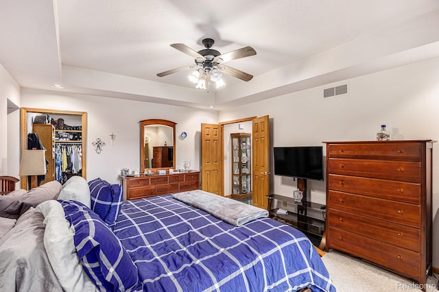 1437 Rillview Ct, Metamora, MI 48455 - bedroom with light colored carpet, a ceiling fan, a closet, a tray ceiling, and a walk in closet