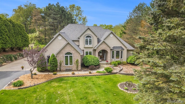 1437 Rillview Ct, Metamora, MI 48455 - traditional home with a front yard, brick siding, a shingled roof, and driveway