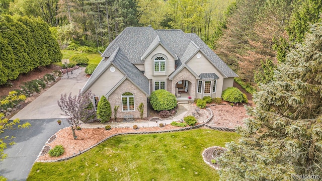 1437 Rillview Ct, Metamora, MI 48455 - view of front of property with a front yard, brick siding, a shingled roof, and a wooded view