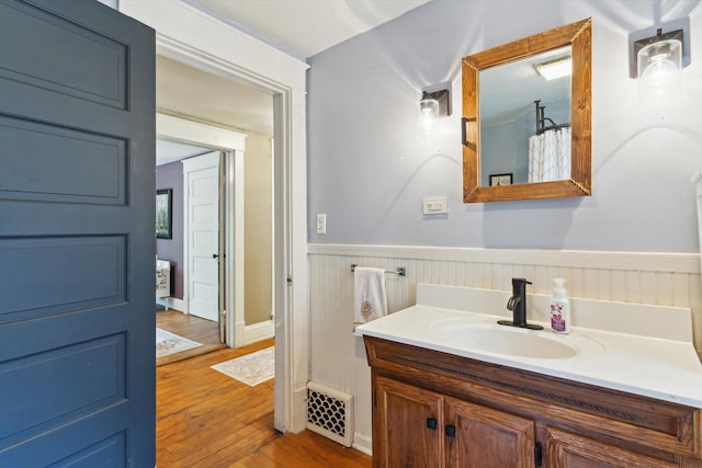 700 S Washington, Mount Pleasant, MI 48858 - bathroom with vanity, wood finished floors, a wainscoted wall, and curtained shower