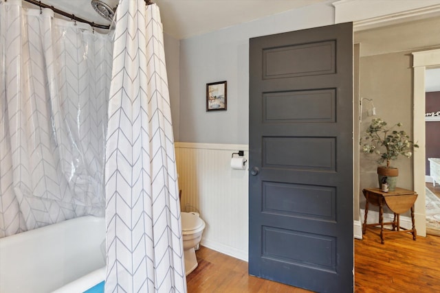 700 S Washington, Mount Pleasant, MI 48858 - bathroom featuring wood finished floors, toilet, a wainscoted wall, and shower / bath combination with curtain