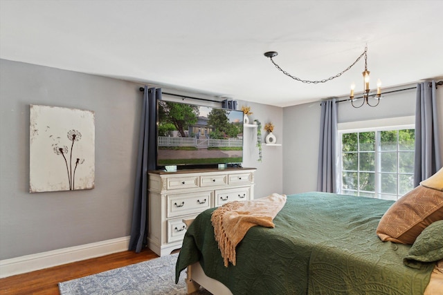 700 S Washington, Mount Pleasant, MI 48858 - bedroom with baseboards, wood finished floors, and a chandelier