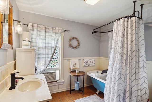 700 S Washington, Mount Pleasant, MI 48858 - bathroom with wainscoting, a freestanding bath, wood finished floors, curtained shower, and cooling unit