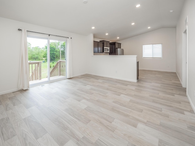 1925 Prescott Trl, Galesburg, MI 49053 - unfurnished living room with recessed lighting, vaulted ceiling, light wood-type flooring, and baseboards