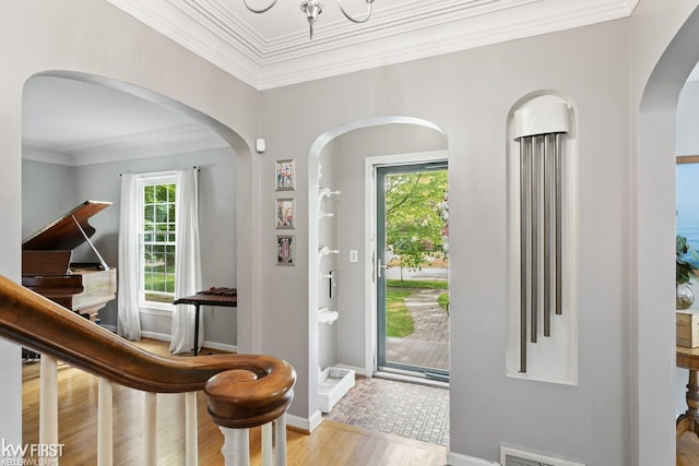 1118 Maxine St, Flint, MI 48503 - foyer entrance featuring wood finished floors, plenty of natural light, crown molding, baseboards, and arched walkways