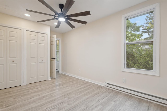 932 Enders Ave, Benton Harbor, MI 49022 - unfurnished bedroom with a baseboard radiator, two closets, light wood finished floors, and recessed lighting