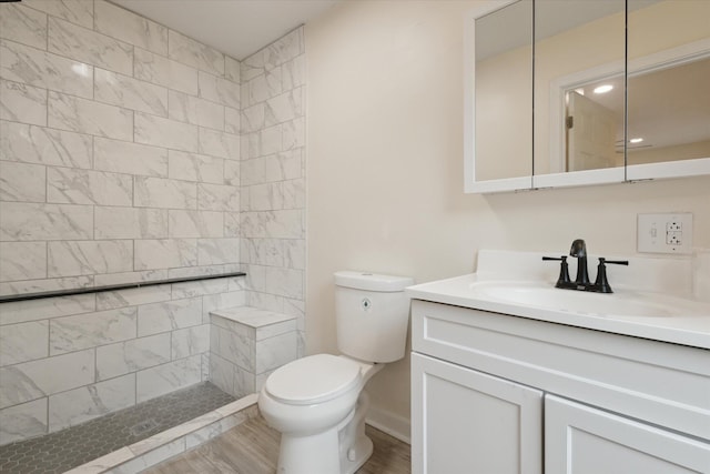932 Enders Ave, Benton Harbor, MI 49022 - bathroom featuring vanity, wood finished floors, toilet, a tile shower, and recessed lighting