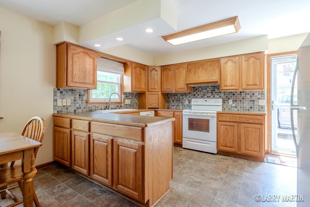 2153 Greenview Ct SW, Wyoming, MI 49519 - kitchen with electric stove, a sink, light countertops, backsplash, and recessed lighting