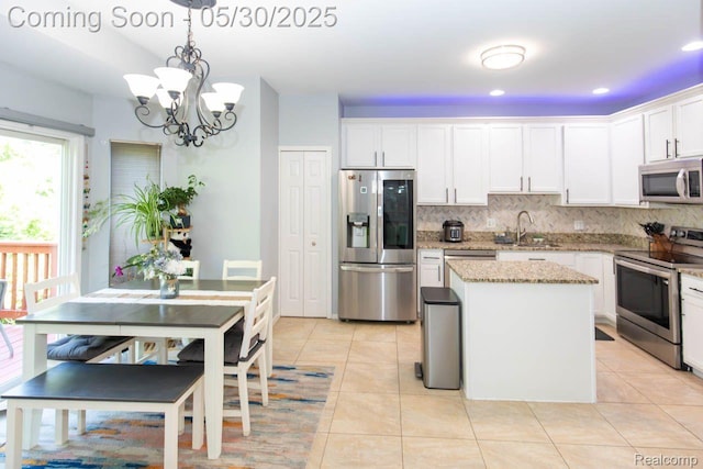 2062 Preserve Cir W, Canton, MI 48188 - kitchen featuring appliances with stainless steel finishes, a sink, light tile patterned floors, light stone counters, and backsplash