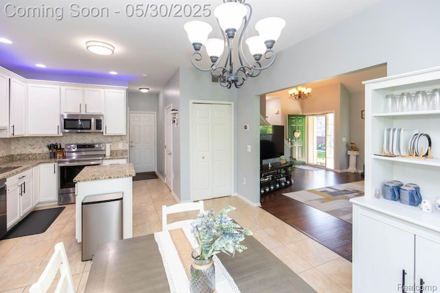 2062 Preserve Cir W, Canton, MI 48188 - kitchen with appliances with stainless steel finishes, a chandelier, light tile patterned flooring, white cabinetry, and decorative backsplash