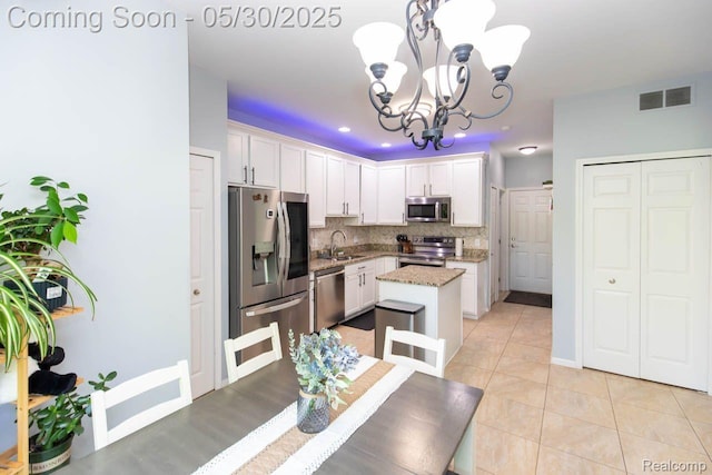 2062 Preserve Cir W, Canton, MI 48188 - kitchen featuring appliances with stainless steel finishes, a sink, a chandelier, white cabinets, and backsplash