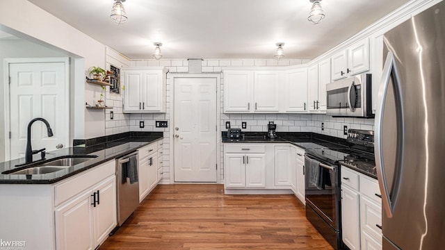 1590 W Rolston Rd, Linden, MI 48451 - kitchen featuring appliances with stainless steel finishes, a sink, white cabinetry, and decorative backsplash