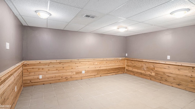 1590 W Rolston Rd, Linden, MI 48451 - empty room featuring wood walls, wainscoting, and a drop ceiling