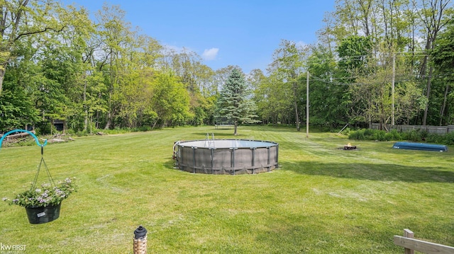 1590 W Rolston Rd, Linden, MI 48451 - view of grassy yard featuring an outdoor pool and an outdoor fire pit