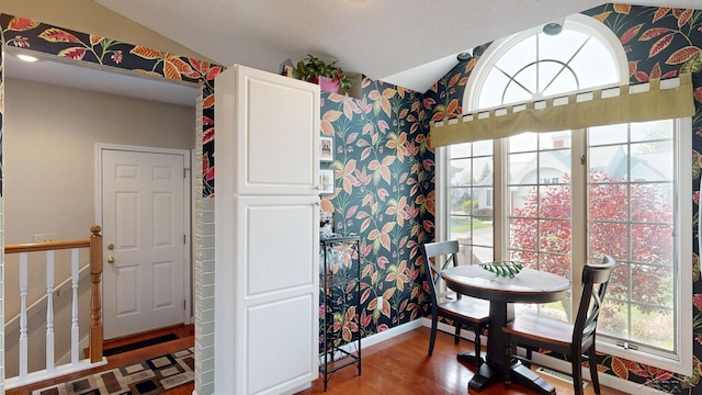 17 E Drake Dr, Saginaw, MI 48603 - dining space with vaulted ceiling, wallpapered walls, plenty of natural light, wood finished floors, and baseboards